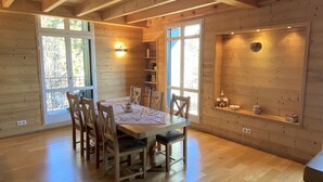 A wooden interior with a dining table, chairs, and a shelf with decorative items. - Superb chalet apartment with views of the Cerdagne - 3 minutes from the cable cars (Font-Romeu-Odeillo-Via)