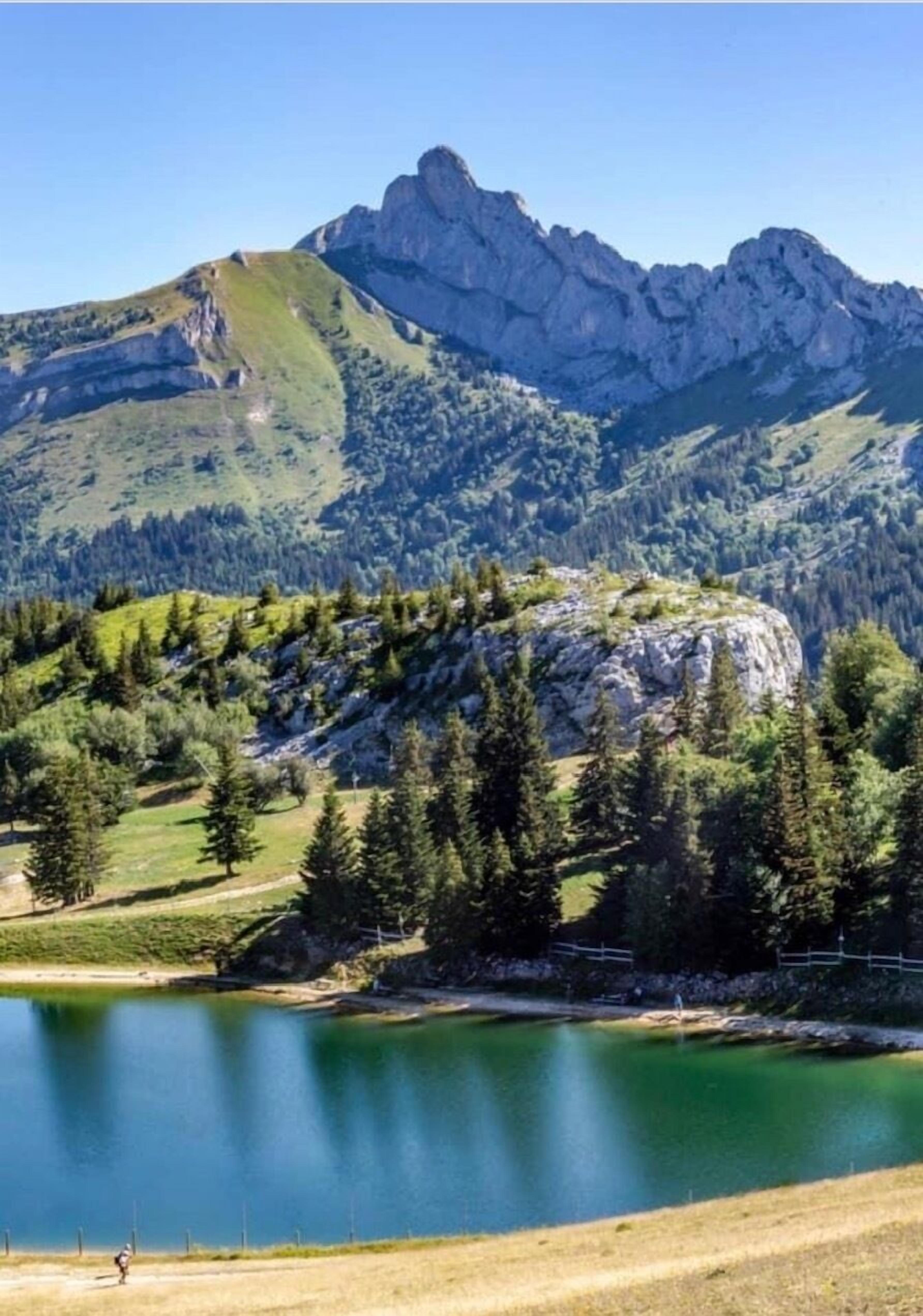 A mountain landscape with a lake and a rocky peak.