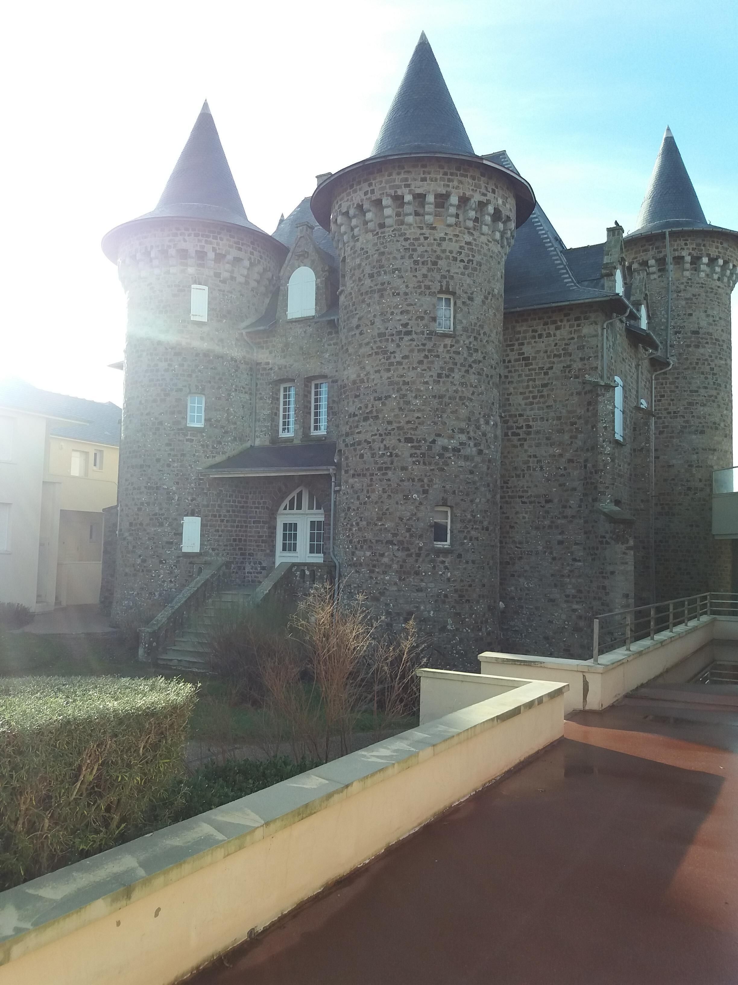 A castle-like building with multiple towers and a central entrance.