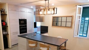 Une cuisine moderne dotée d’un îlot central, de tabourets de bar et d’une table à manger.