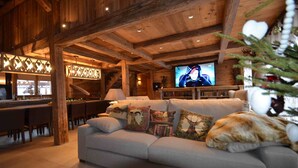 Een gezellige woonkamer met een bank, een televisie en een kerstboom.