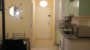 A compact kitchen with a washing machine, a microwave, and a sink. - Panoramic sea and pond view not overlooked. (Mauguio)