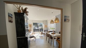 A modern kitchen with a dining area, large windows, and a view of the outdoors. - 30m from the beach, air-conditioned house, sea view, enclosed garden, ideal for families (Saint-Raphaël)