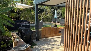 A patio area with outdoor furniture, a stone basin, and a wooden fence. - 30m from the beach, air-conditioned house, sea view, enclosed garden, ideal for families (Saint-Raphaël)