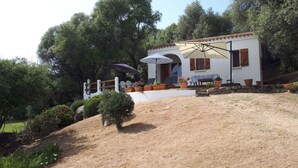 A house with a patio area, outdoor seating, and potted plants.