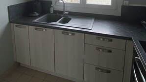 Una cocina con un lavamanos doble, armarios y una ventana con vistas a la ciudad.