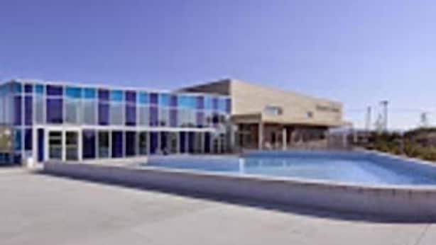 Un edificio moderno con una piscina delantera.