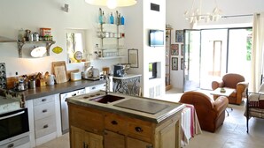 A kitchen with a central island, a dining area with a table and chairs, and a television mounted on the wall.