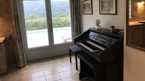 A piano in a room with a large sliding glass door leading to a balcony. - Large salted swimming pool heated from May to September for 4 people (Vence)