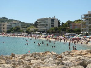 A crowded beach with people swimming and sunbathing, surrounded by buildings and umbrellas. - CAP D'ANTIBES 3 PIECES OF CHARACTER WITH AC NEAR SAND BEACH - SANDY BEACH (Antibes)