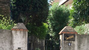 Une entrée fermée par un portail, sur laquelle on peut lire l’inscription « Chantecler » et où le chiffre « 4 » est peint sur un mur.