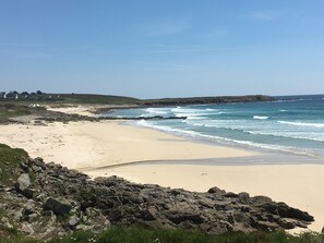 Une plage côtière avec un terrain rocheux et un ciel dégagé.