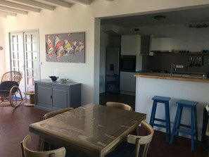 A compact living space with a dining area, kitchen, and a large window.