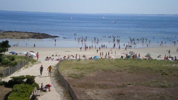 A beach with people, umbrellas, and boats. - view apartment stunning sea views (Carnac)