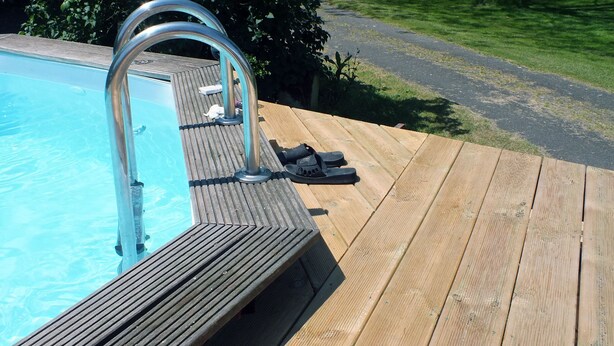 A wooden deck with a pool and a metal ladder. - Perigordian style property (Saint-Pierre-d'Eyraud)