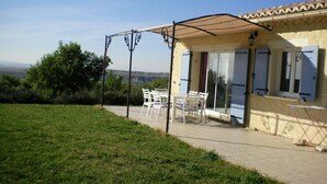 Una casa con un patio, una mesa y sillas.