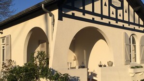 Un edificio con fachada blanca, detalles negros y varias ventanas arqueadas.