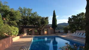 A swimming pool with a clear blue water, surrounded by lounge chairs and a pergola. - House in Grimaud with exceptional views of the sea and the Gulf of Saint-Tropez (GRIMAUD)