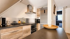 A modern kitchen with a large island, stainless steel appliances, and a view to the outside. - Calm & Cosy by the sea - 4 people - Fully equipped (Saint-Raphaël)