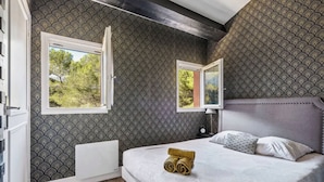 A bedroom with a bed, two windows, a radiator, and a mirror on the wall. - Calm & Cosy by the sea - 4 people - Fully equipped (Saint-Raphaël)