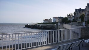 A coastal promenade with a white metal railing, benches, and a stone wall. - PIGEONNIER BEACH 5 'ON FOOT; BEACH DE PONTAILLAC 8 'all on foot (Royan)