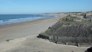 Une plage avec une clôture en bois et un ciel dégagé.