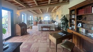 Amplia sala de estar con techo alto, chimenea, zona de comedor y estantería.
