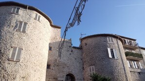 A historic stone building with arched doorways and multiple windows, featuring a mix of stone and plaster textures. - AIR-CONDITIONED, SINGLE-STOREY VILLA, SEA AND CORSICAN VIEWS LARGE GARDEN, DOGS ALLOWED (Villeneuve-Loubet)