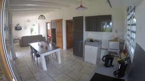 A modern kitchen with a dining area, a washing machine, and a coffee maker. - Villa Marga: pretty new Creole villa (Capesterre - Belle - Eau)