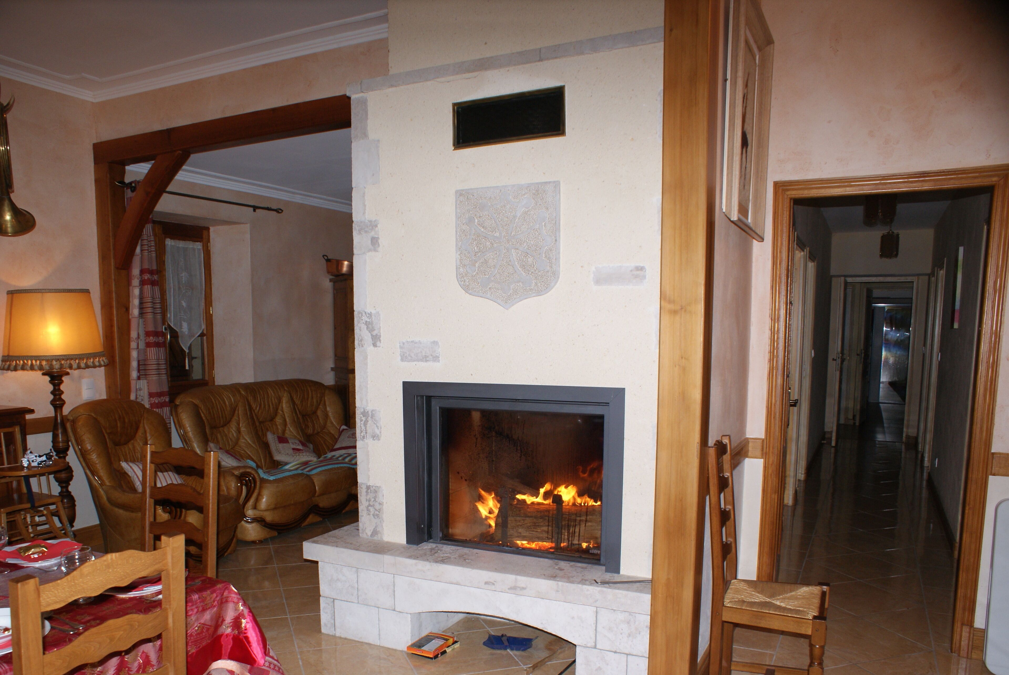 A living room with a fireplace, a sofa, a table, and a lamp.
