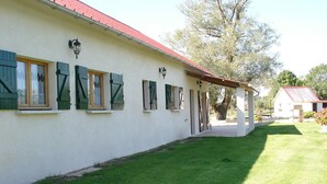 A white building with green shutters, a red roof, and a covered outdoor area. - very beautiful house of 140m2 located in a private property (Quend)