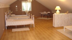 A bedroom with two beds, a chandelier, a table, and a lamp. - very beautiful house of 140m2 located in a private property (Quend)