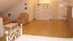 A cozy attic bedroom with a bed, two chairs, a small table, and a built-in bookshelf. - very beautiful house of 140m2 located in a private property (Quend)