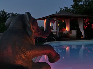 A sculpture of an elephant by a pool with a gazebo in the background. - Cozy apartment with pool access, unobstructed view of the valley, quiet (Garéoult)