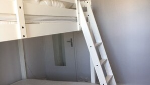 A bunk bed with a ladder, a door, and a small window. - Apartment for rent in family residence (Le Grau-du-Roi)