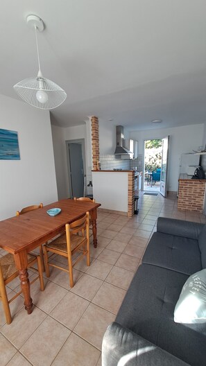 A modern living space with a dining area, kitchen, and seating area.