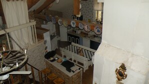 Een landelijke keuken met een houten plafond, een geruite vloer en een stenen muur.