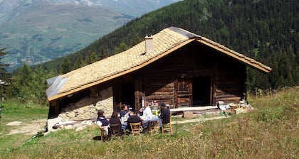Chalet savoyard typique avec un toit en tavaillons, des murs en tuf et en fuste