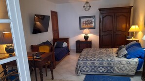 A bedroom with a bed, a desk, a chair, a TV, a wardrobe, and a lamp. - Sea views, 2 beautiful terraces, charming duplex in villa, landscaped garden   (Brando)