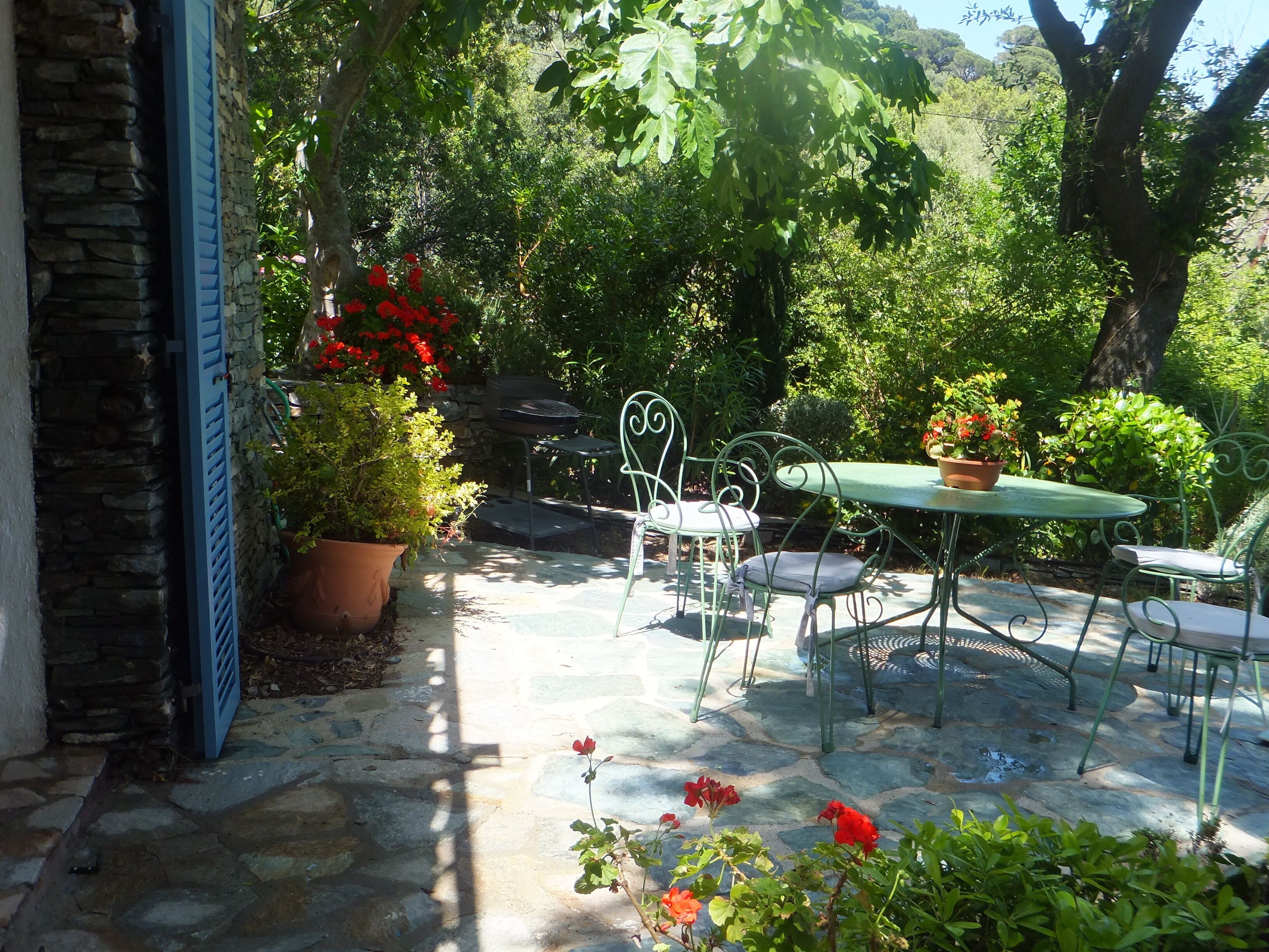 Un patio con suelo de piedra, una mesa y sillas.