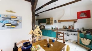A kitchen with teal cabinets, a stove, and a red flag on the wall.