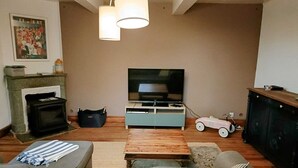 A living room with a sofa, a coffee table, a TV, a fireplace, and a toy car.