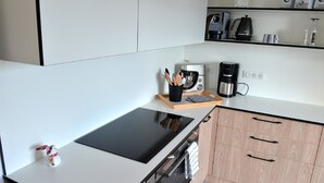 Eine moderne Küche mit schwarzem Arbeitsplatz, Holzschränken und einer Kaffeemaschine.