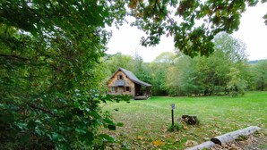 A rustic cabin with a porch, surrounded by a grassy area and dense trees. - Burgundy, cottage, cottage, calm, tranquility, rest, southern Morvan (Corancy)