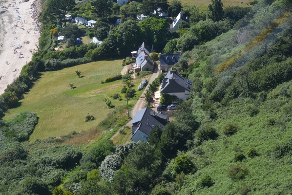 A coastal property with multiple houses, a beach, and a well-maintained lawn. - House direct access to the beach from the garden. (Trébeurden)