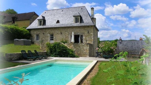 A stone house with a swimming pool, a garden, and a stone wall. - Renovated house in black Périgord with private pool and wifi for 6/8 people (Montignac)