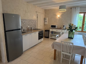 A compact kitchen with a refrigerator, oven, microwave, and a dining area with a table and chairs. - Top of home, air conditioner, private entrance, private garden, parking (Serra-Di-Ferro)