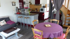 A compact living space with a kitchen, dining area, and a sofa. - Séné seaside lodging (classified 2 stars) (Séné)