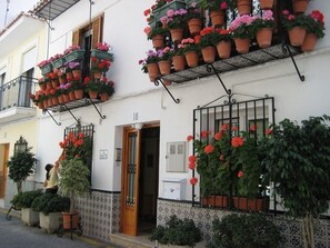 A building with multiple balconies adorned with potted plants and flowers.