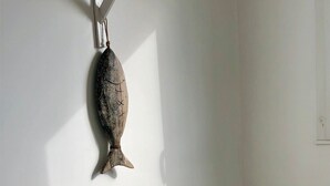 A room with a bed, pillows, and a wall-mounted fish decoration. - 180° sea view-Terrace-Rooftop-Plage-City center-Fiber-Netflix-Clim-Garage   (Arcachon)